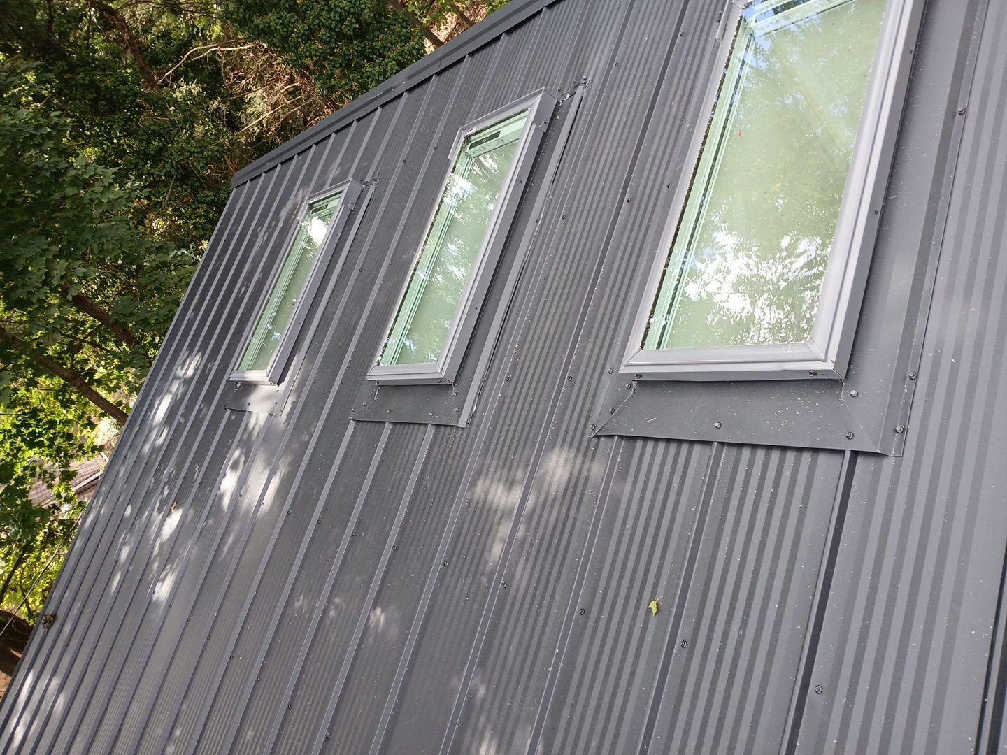 exposed fastener metal roof with black textured pro appearance panels and skylights 