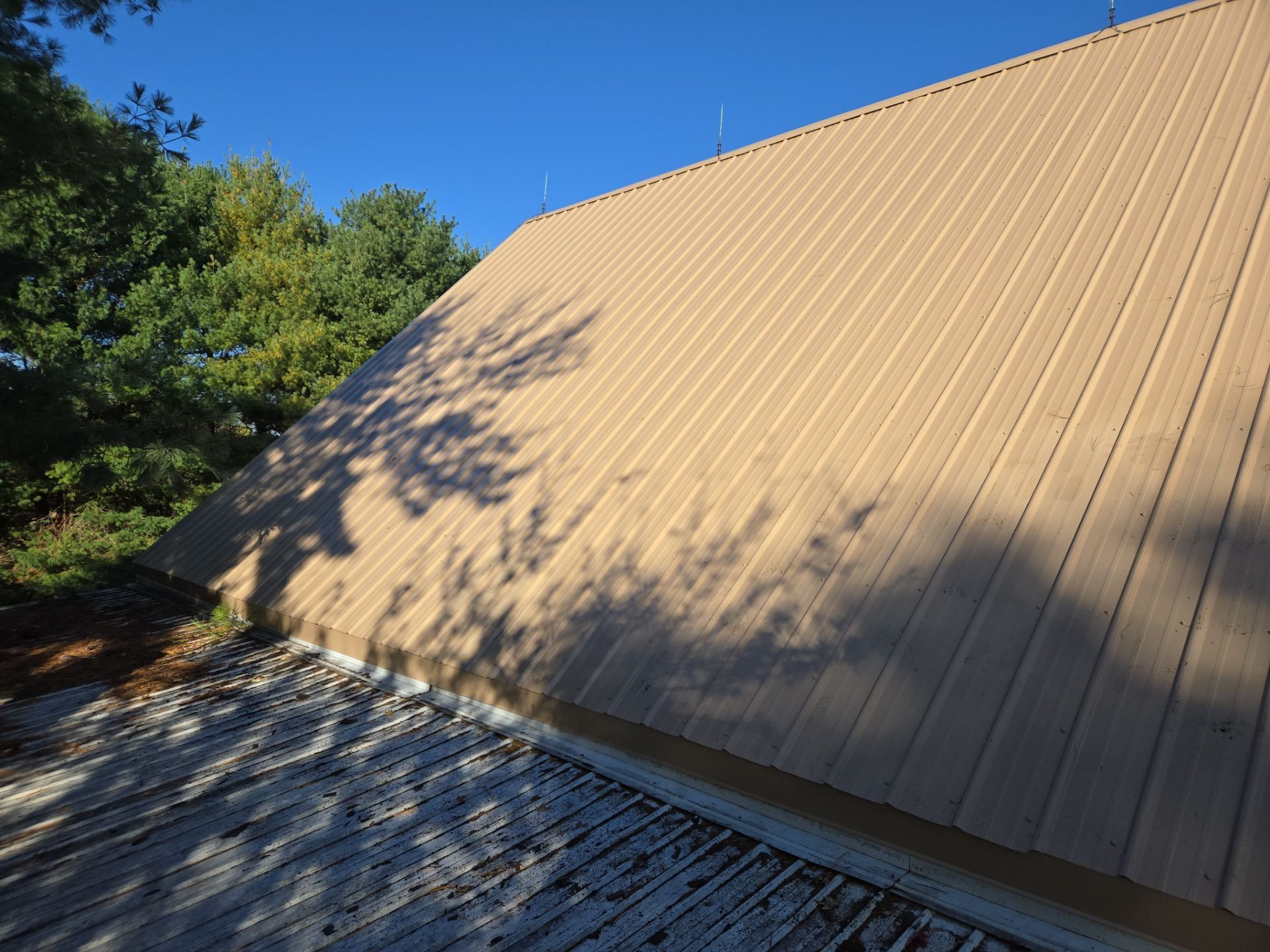Finished metal roof with exposed fastener panels
